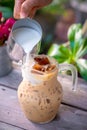 Pouring milk in a glass with latte coffee and iced Royalty Free Stock Photo