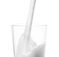 Pouring milk into glass (milk splash) isolated Royalty Free Stock Photo