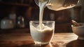 Pouring milk into a glass on wooden background Royalty Free Stock Photo