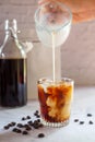 Pouring milk in to a glass of homemade cold brew coffee Royalty Free Stock Photo