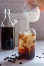 Pouring milk in to a glass of homemade cold brew coffee Royalty Free Stock Photo