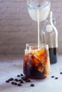Pouring milk in to a glass of homemade cold brew coffee Royalty Free Stock Photo