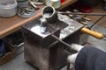 Pouring molten lead alloy into a mold. Workshop.