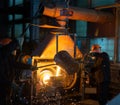 Pouring molten metal into a centrifugal machine in the foundry shop of metallurgical plant