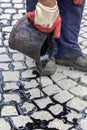 Pouring molten pitch from a tar bucket