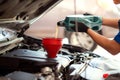 Pouring oil to car engine, Mechanic pouring oil into car Royalty Free Stock Photo