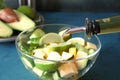 Pouring of olive oil onto tasty vegetable salad on green table, closeup Royalty Free Stock Photo