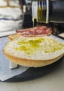 Pouring olive oil over freshly made toast slice