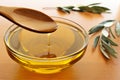 Pouring olive oil from wooden spoon to glass bowl Royalty Free Stock Photo