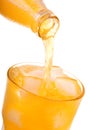 Pouring orange soda into glass with ice from bottle