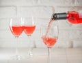 Pouring pink wine from bottle into wineglass Royalty Free Stock Photo