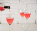 Pouring pink wine from bottle into wineglass Royalty Free Stock Photo