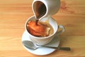 Pouring a pitcher of hot espresso coffee onto the cup of vanilla ice cream for an aromatic and tasty Affogato Royalty Free Stock Photo