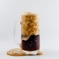 Pouring process of dark stout beer into a beer glass mug, splashes, drops and froth around glass mug Royalty Free Stock Photo