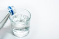 Pouring pure fresh mineral non-carbonated water into a glass beaker on a white background from a plastic bottle Royalty Free Stock Photo