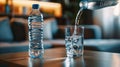 pouring purified fresh drink water from bottle in living room, close up view on table, healthy lifestyle