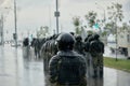 In the pouring rain, riot police in full tactical gear prepare to confront the protesters in the Belarus Royalty Free Stock Photo