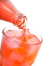 Pouring red soda into glass with ice from bottle Royalty Free Stock Photo