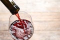 Pouring red wine from bottle into glass on blurred background Royalty Free Stock Photo