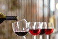 Pouring red wine from bottle into glass indoors, closeup. Space for text Royalty Free Stock Photo