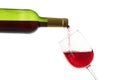 Pouring of red wine from bottle into glass on white background Royalty Free Stock Photo