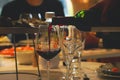 Pouring red wine from bottle into glasses on table Royalty Free Stock Photo