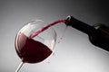 Pouring red wine from bottle into the wineglass Royalty Free Stock Photo