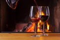 Pouring red wine at cozy fireplace Royalty Free Stock Photo
