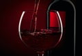 Pouring red wine into the glass against red black background Royalty Free Stock Photo