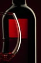 Pouring red wine into the glass against red black background Royalty Free Stock Photo