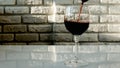 Pouring red wine into a glass on a brick wall background,close-up Royalty Free Stock Photo