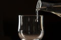 pouring red wine into a glass from a clay bottle on a black background Royalty Free Stock Photo