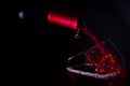 Pouring red wine glass on dark light Royalty Free Stock Photo