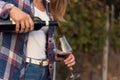 Young woman pours red wine into a glass. Vineyard as background Royalty Free Stock Photo