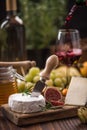 Pouring red wine into glass and serving with camembert Royalty Free Stock Photo