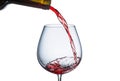 Pouring red wine into a glass with splashes on a white background Royalty Free Stock Photo