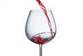 Pouring red wine into a glass with splashes on a white background Royalty Free Stock Photo