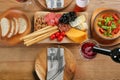 Pouring red wine into glass on table with delicious food Royalty Free Stock Photo