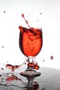 Pouring red wine into a glass of water Royalty Free Stock Photo