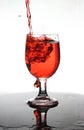 Pouring red wine into a glass of water Royalty Free Stock Photo