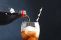 Pouring refreshing cola into glass with ice cubes Royalty Free Stock Photo