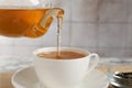 Pouring refreshing green tea from teapot into cup at table, closeup Royalty Free Stock Photo