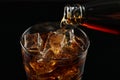 Pouring refreshing soda water from bottle into glass on black background, closeup Royalty Free Stock Photo