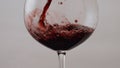 Pouring rose wine glass goblet in super slow motion close up. Red merlot flowing Royalty Free Stock Photo