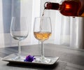 Pouring of rose wine from Provence in two glasses in sunny day