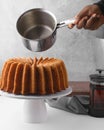Pouring a rum sauce on rum bundt cake Royalty Free Stock Photo