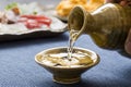 Pouring sake into a small Japanese cup