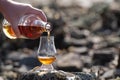 Pouring of Scotch whisky in tasting glass