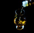 Pouring single malt whisky into a glass, golden color whisky