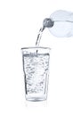 Pouring soda water from bottle into glass on white background Royalty Free Stock Photo